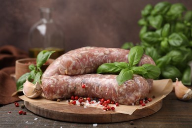 Raw homemade sausages and different spices on wooden table