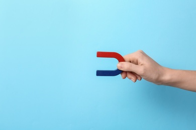 Photo of Woman holding magnet on color background, closeup. Space for text