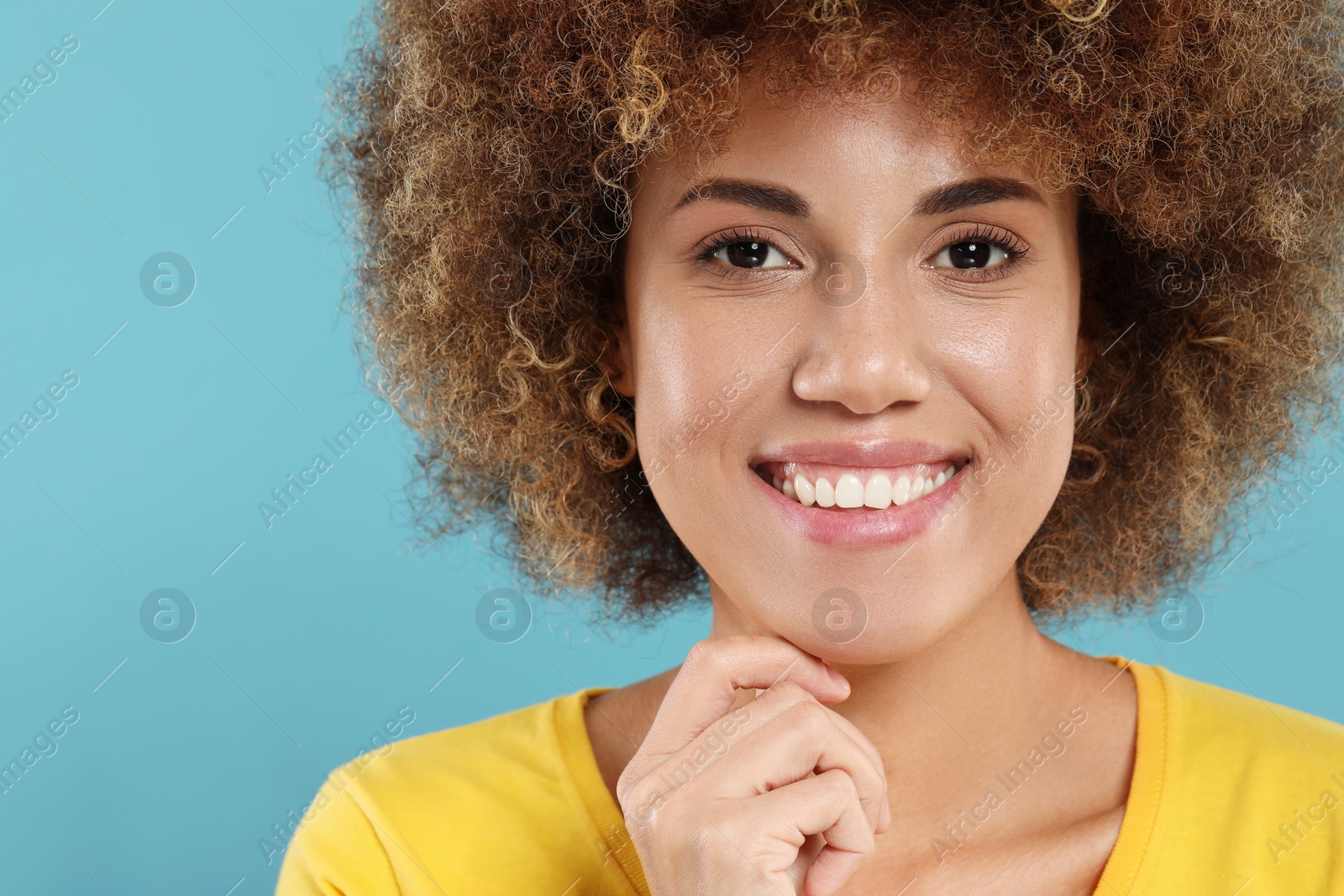 Photo of Woman with clean teeth smiling on light blue background, space for text