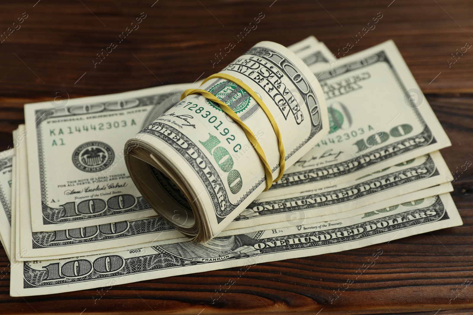 Photo of Money exchange. Dollar banknotes on wooden background, closeup