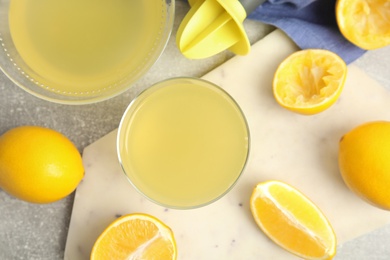 Photo of Freshly squeezed lemon juice on grey table, flat lay