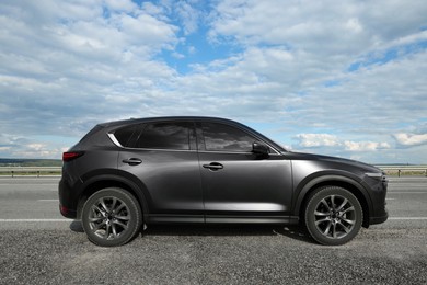 Photo of New black modern car on asphalt road