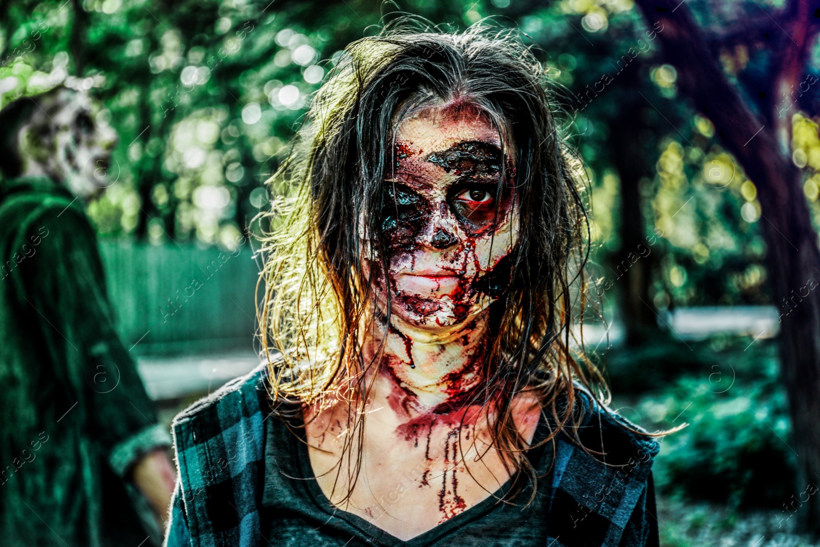 Photo of Scary zombies with bloody faces outdoors. Halloween monster