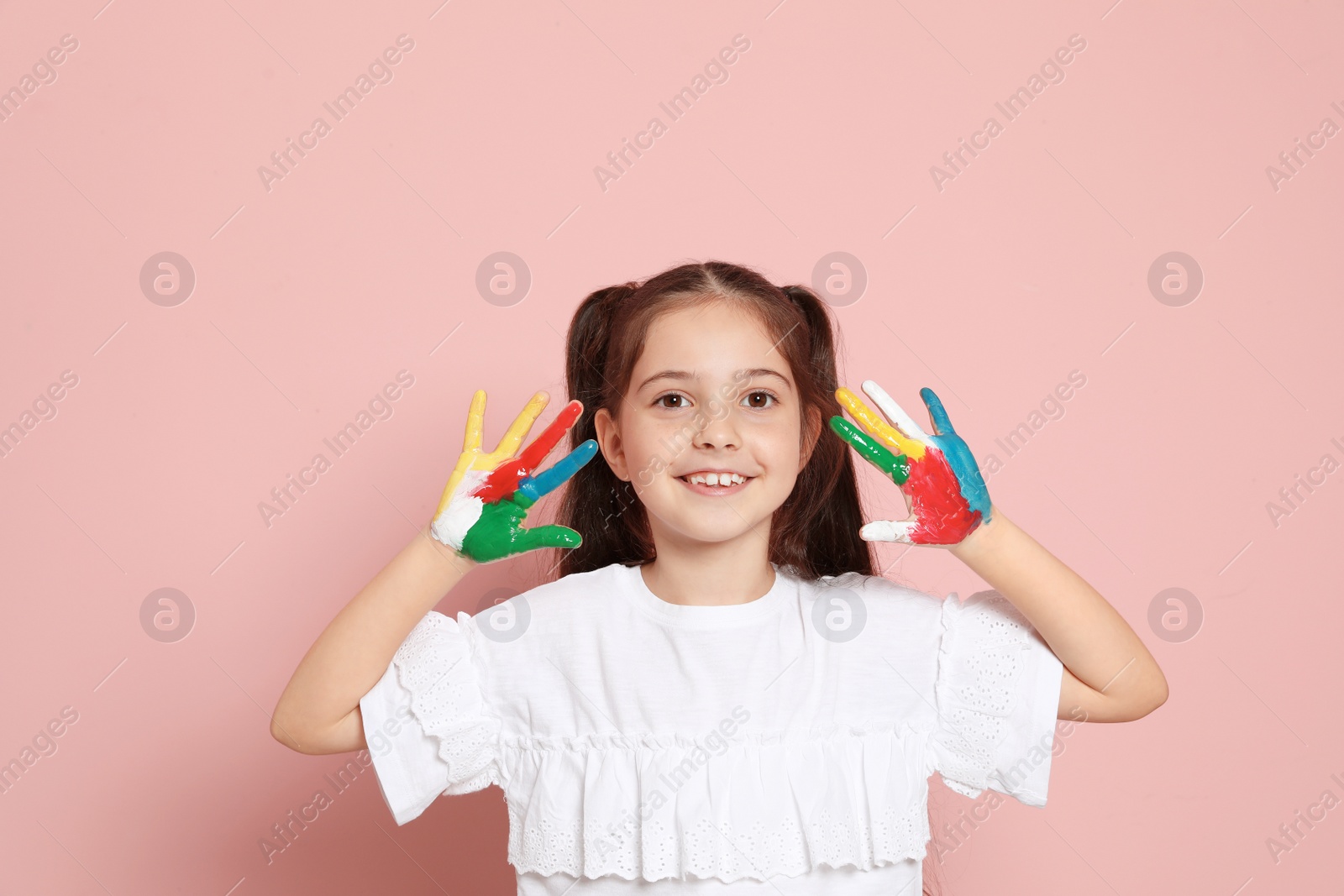 Photo of Little child with painted hands on color background
