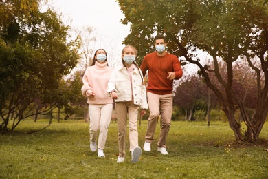 Lovely family walking together in park during coronavirus pandemic