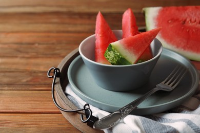 Photo of Sliced fresh juicy watermelon and fork on wooden table, closeup. Space for text