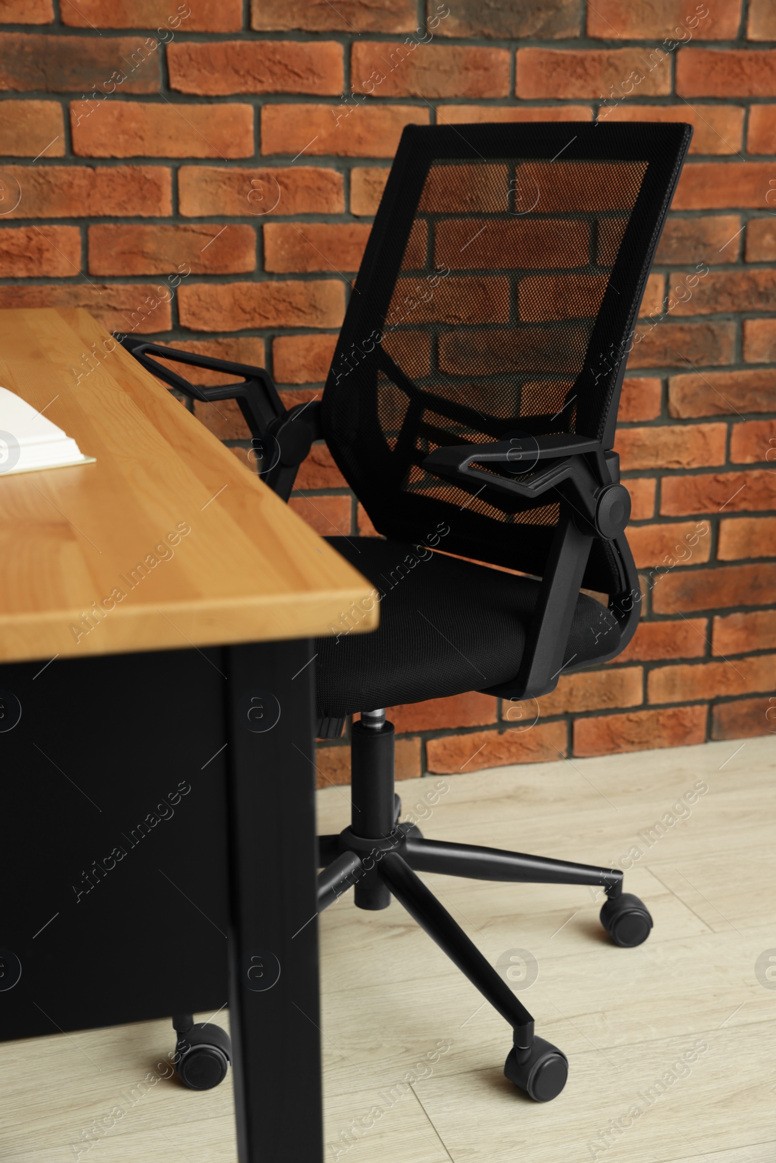 Photo of Comfortable office chair near desk at workplace