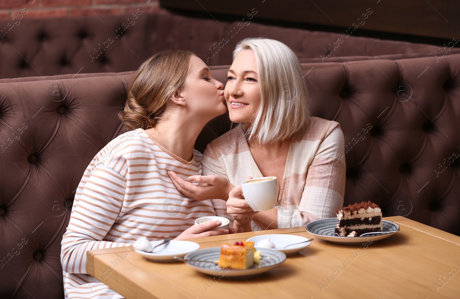 Photo of Mother and her adult daughter spending time together in cafe