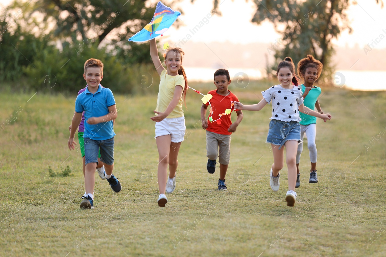 Photo of Cute little children playing with kite outdoors