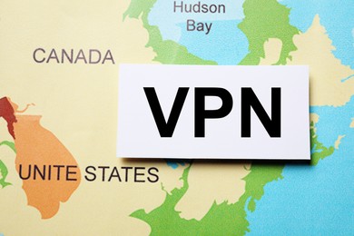 Photo of Paper sheet with acronym VPN (Virtual Private Network) on world map, flat lay