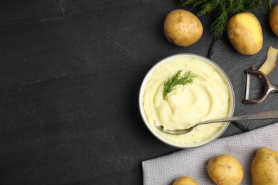 Freshly cooked homemade mashed potatoes and raw vegetables on black table, flat lay. Space for text