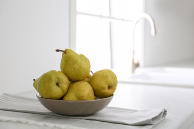 Photo of Fresh ripe pears on countertop in kitchen. Space for text