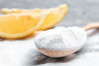 Photo of Spoon with baking soda on grey table, closeup