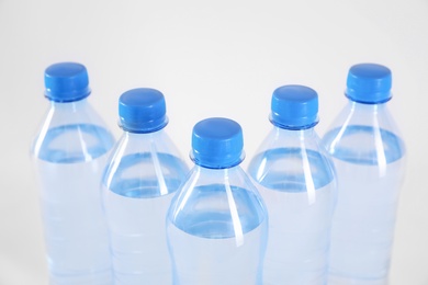 Plastic bottles with pure water on white background, closeup