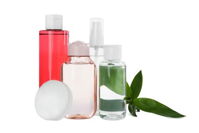 Photo of Bottles of micellar cleansing water, cotton pads and green plant on white background