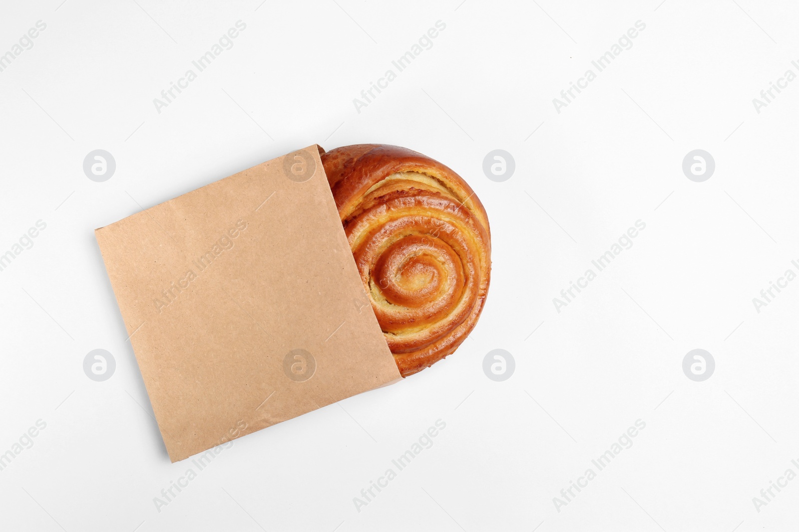 Photo of Paper bag with bun on white background, top view. Space for design