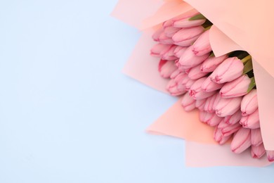 Photo of Bouquet of beautiful pink tulips on light grey background, above view. Space for text