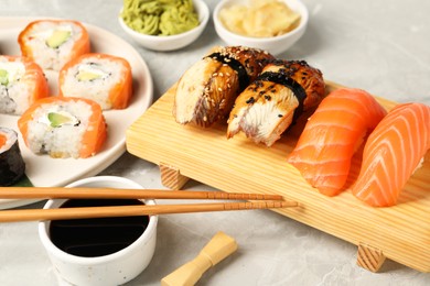 Photo of Delicious sushi rolls on light grey marble table