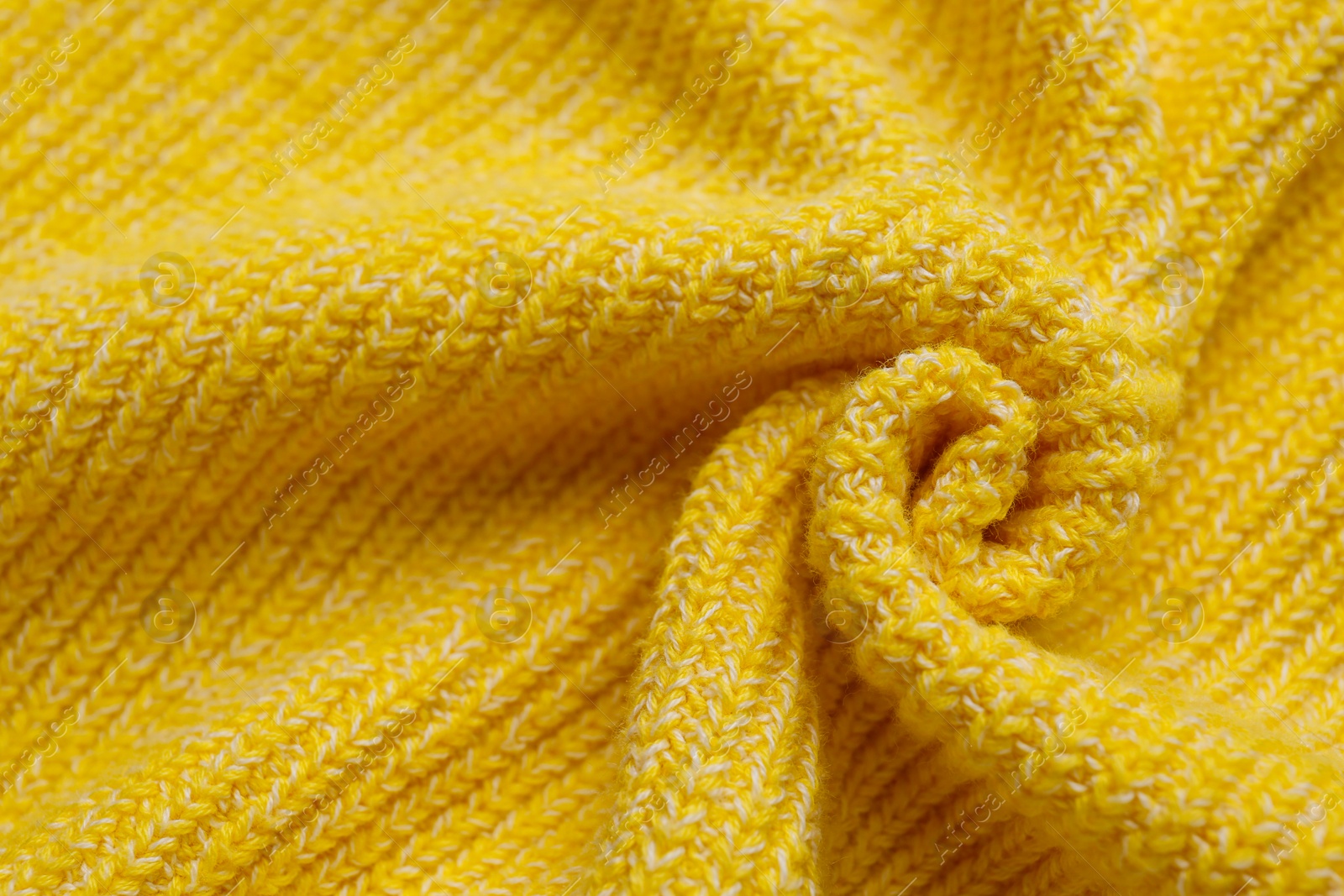 Photo of Yellow knitted fabric as background, top view