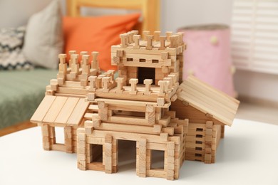 Wooden castle on white table indoors. Children's toy