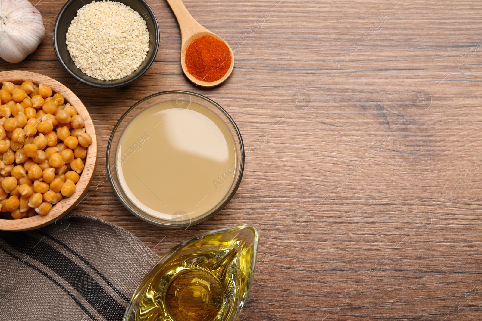 Photo of Different ingredients for hummus on wooden table, flat lay. Space for text.