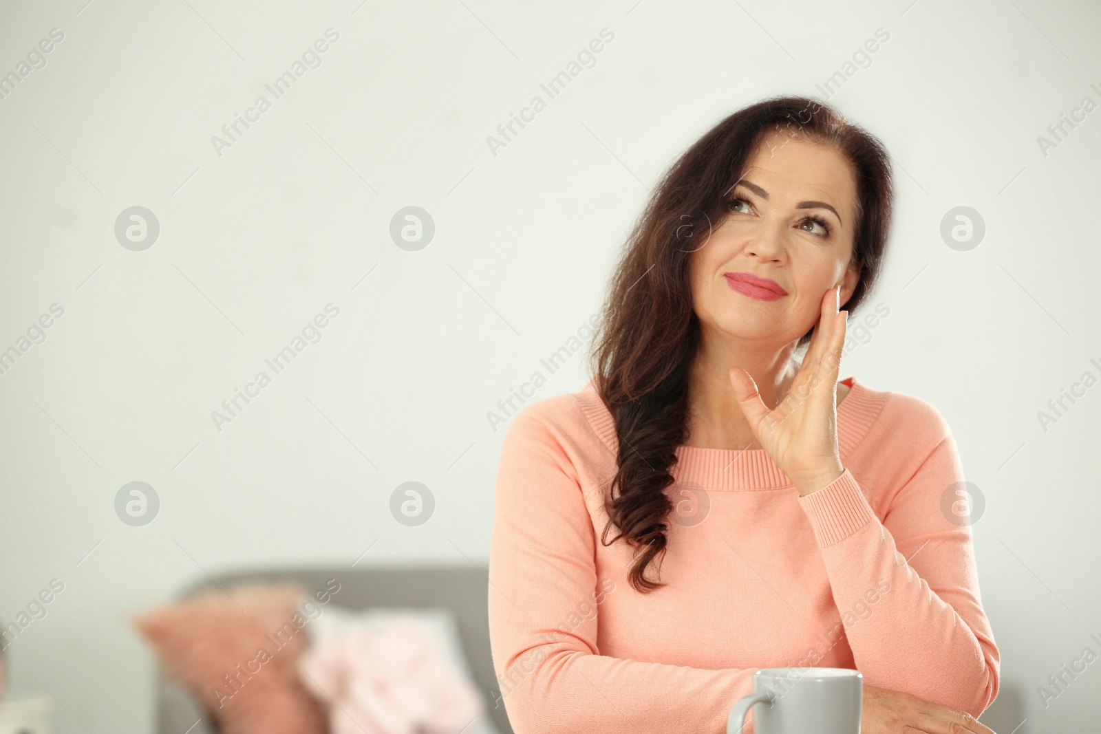Photo of Portrait of beautiful older woman sitting at table indoors. Space for text