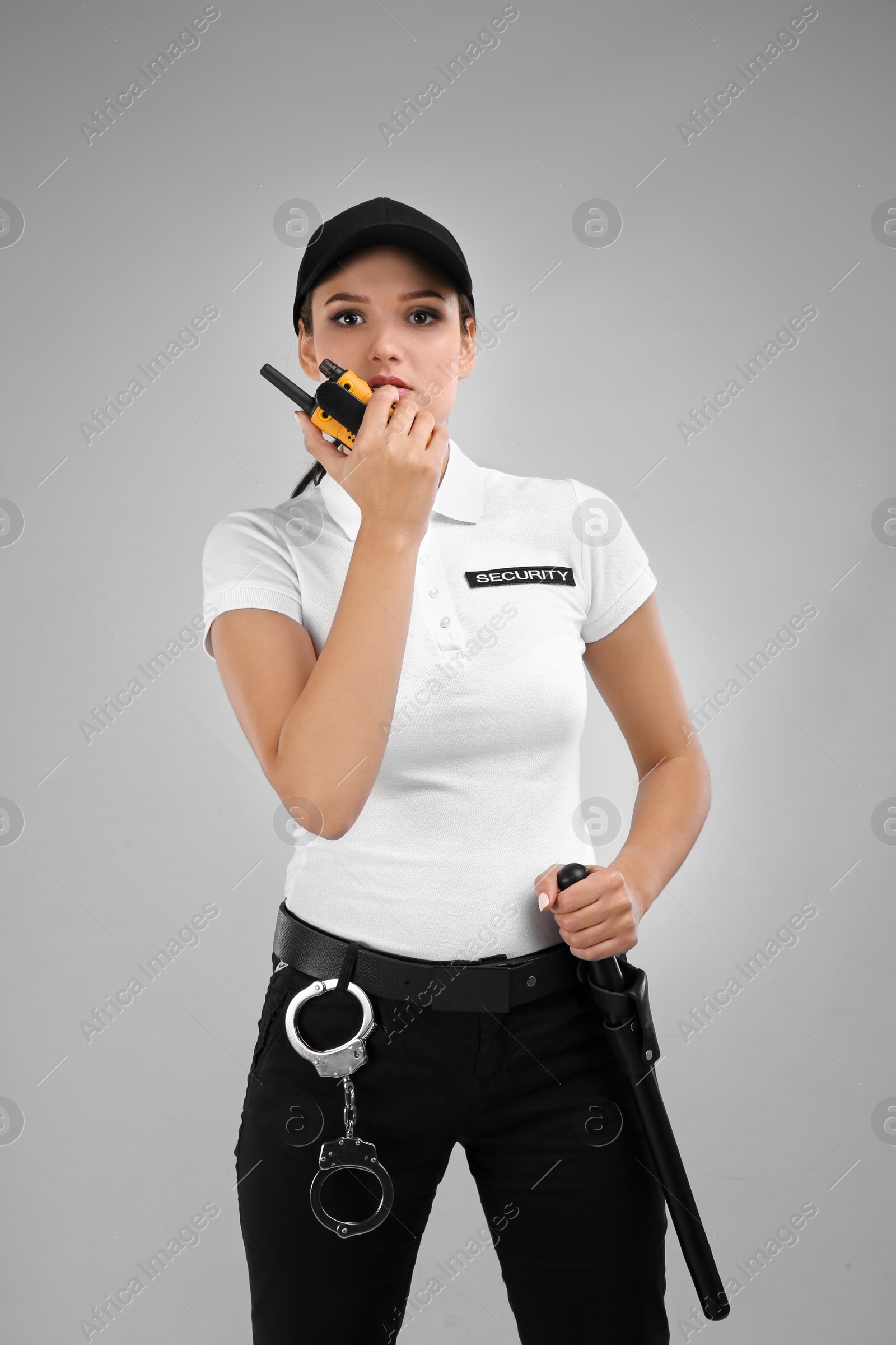 Photo of Female security guard using portable radio transmitter on color background