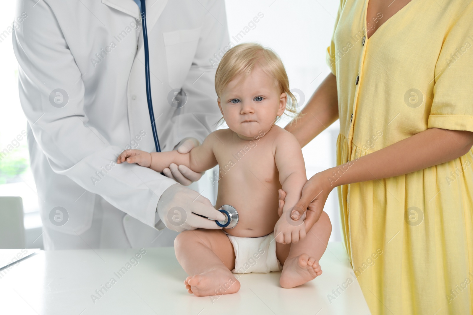 Photo of Pediatrician examining baby with stethoscope in hospital. Health care