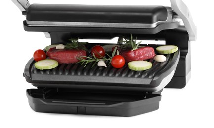 Electric grill with raw meat, rosemary and vegetables isolated on white