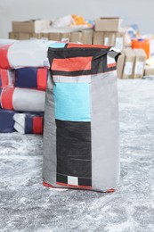 Cement powder in bag on stone floor indoors