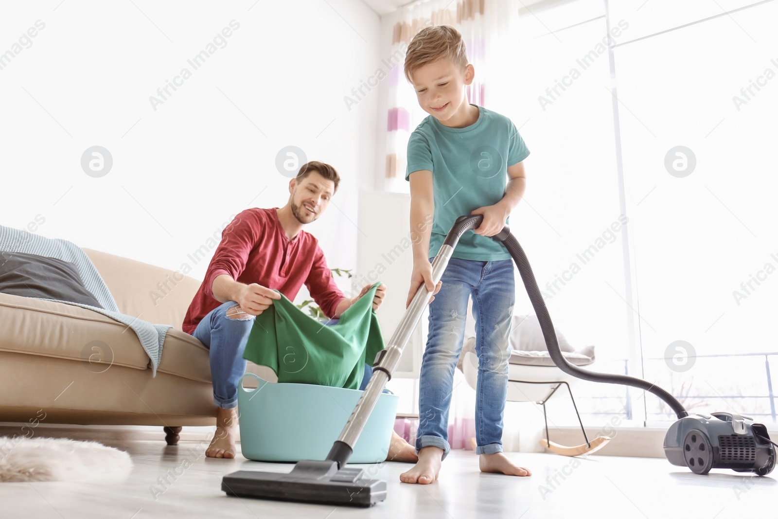 Photo of Little boy and his dad cleaning their house together