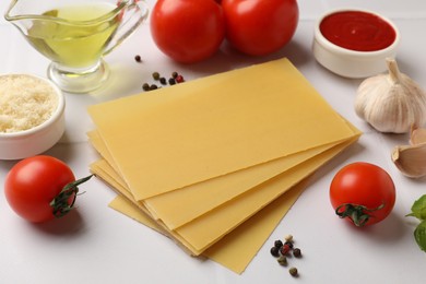 Photo of Ingredients for lasagna on white tiled table, closeup