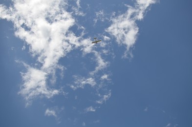 Modern airplane flying in sky with clouds