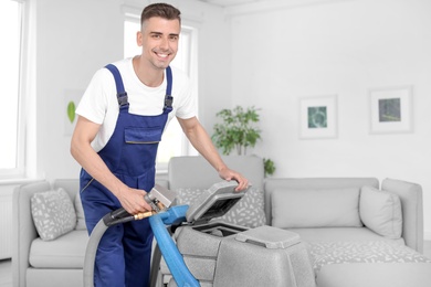 Photo of Dry cleaning worker with professional apparatus indoors