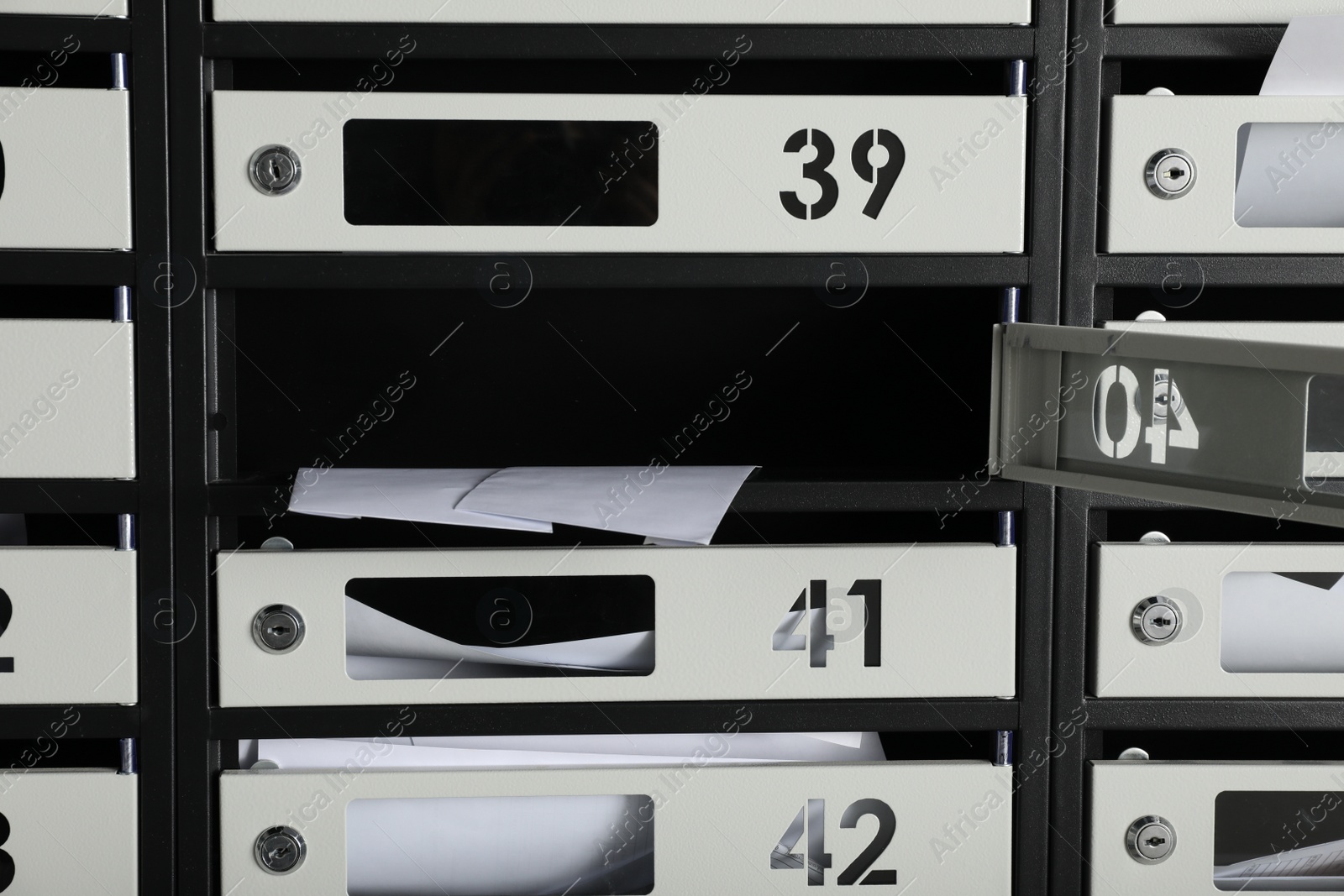 Photo of Open mailbox with keyhole, number and receipts