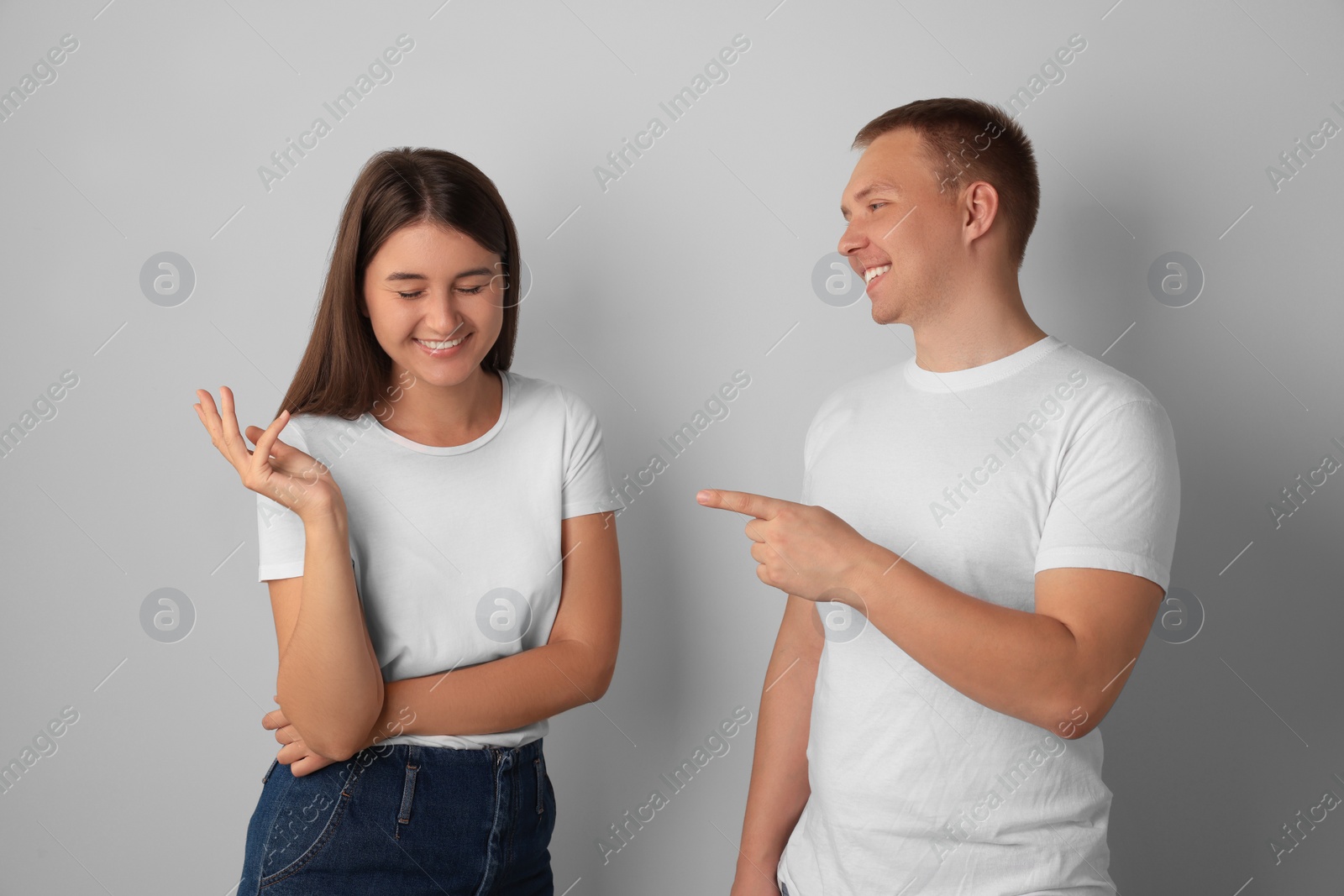 Photo of Happy young people talking on light background