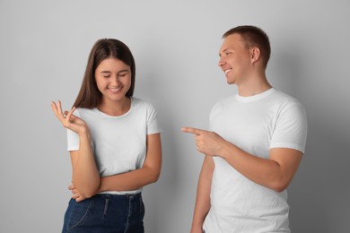 Photo of Happy young people talking on light background