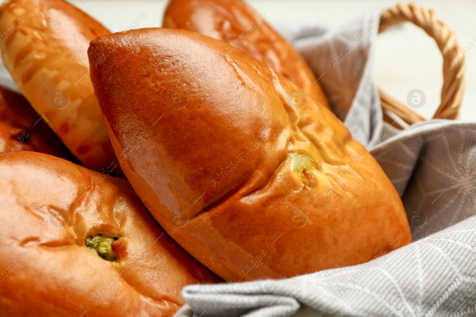 Photo of Basket with delicious baked patties, closeup view