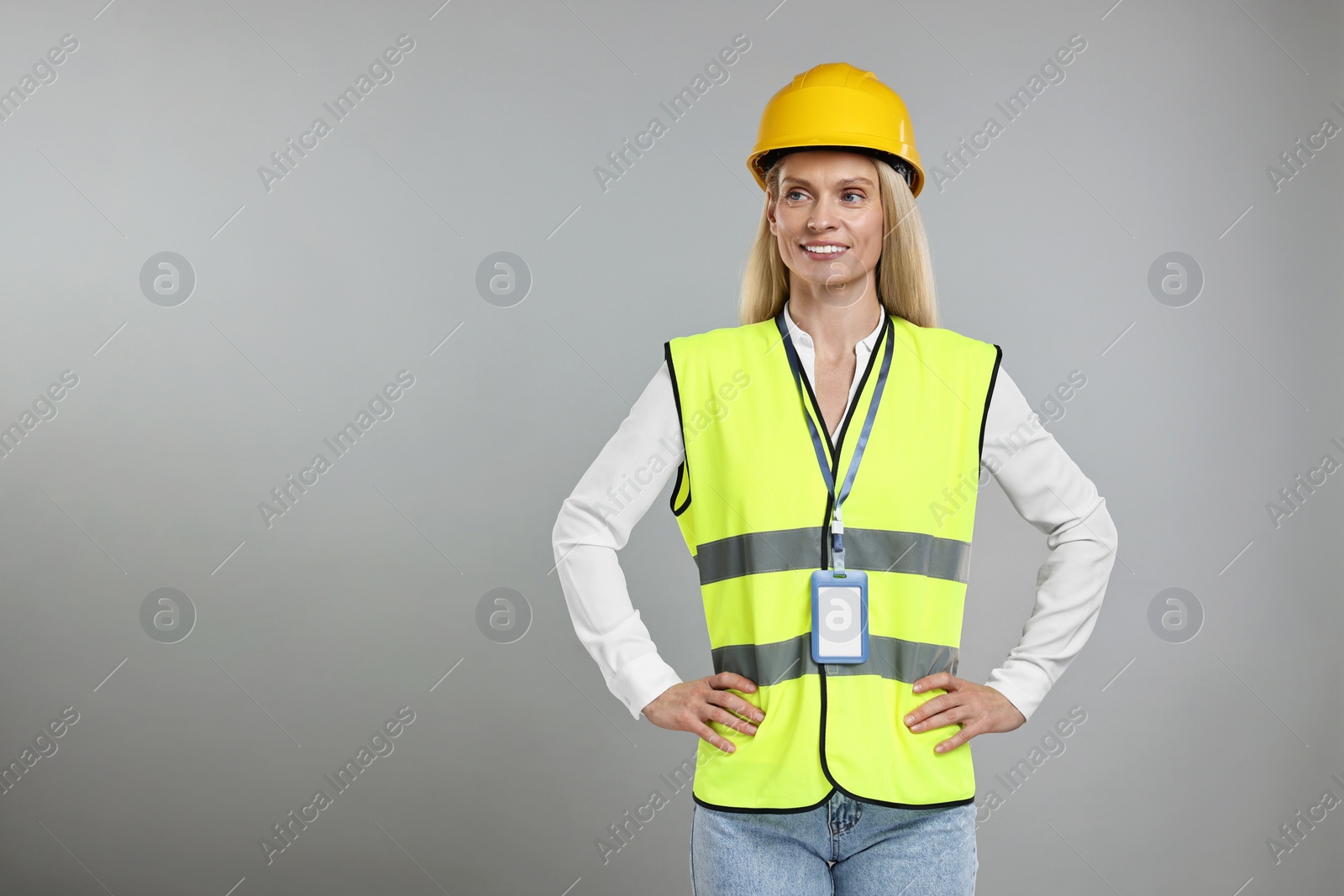 Photo of Engineer with hard hat and badge on grey background, space for text