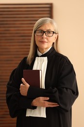 Portrait of judge in court dress with book indoors