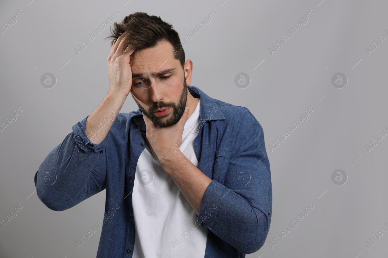 Photo of Man suffering from sore throat on grey background. Cold symptoms