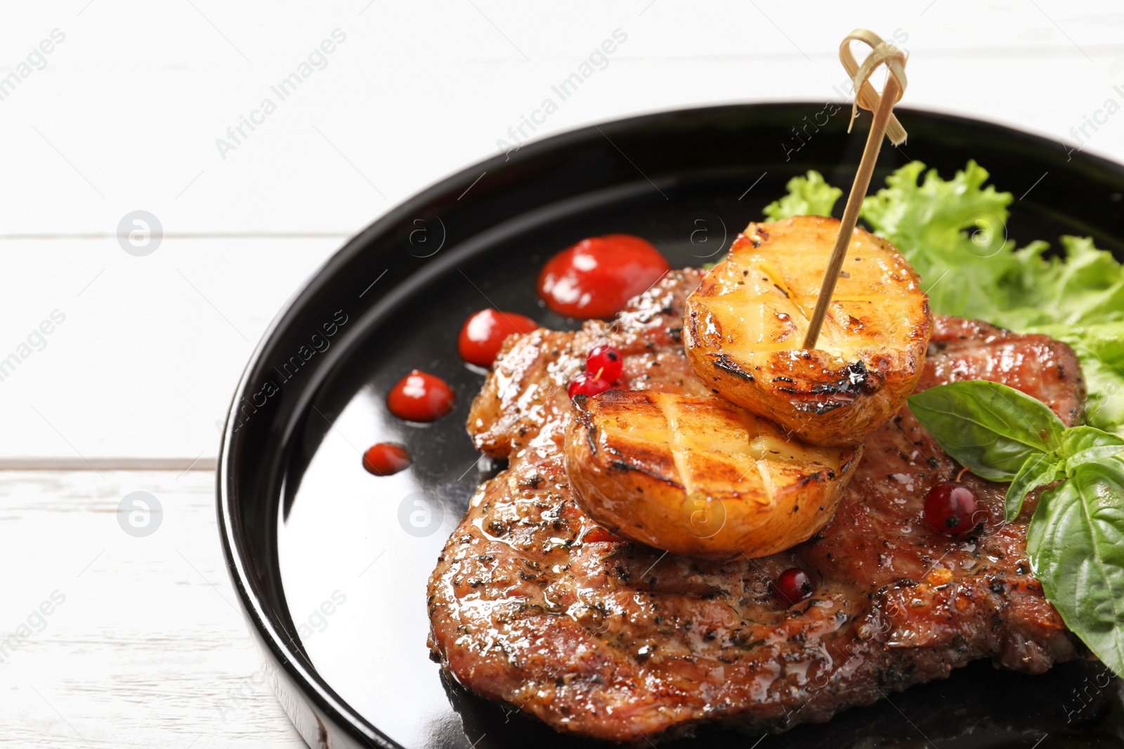 Photo of Plate with tasty grilled meat and potatoes on table, closeup