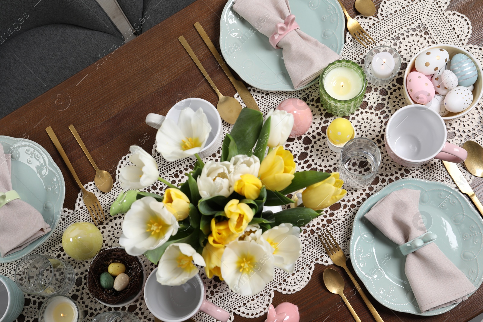 Photo of Festive table setting with beautiful flowers, flat lay. Easter celebration