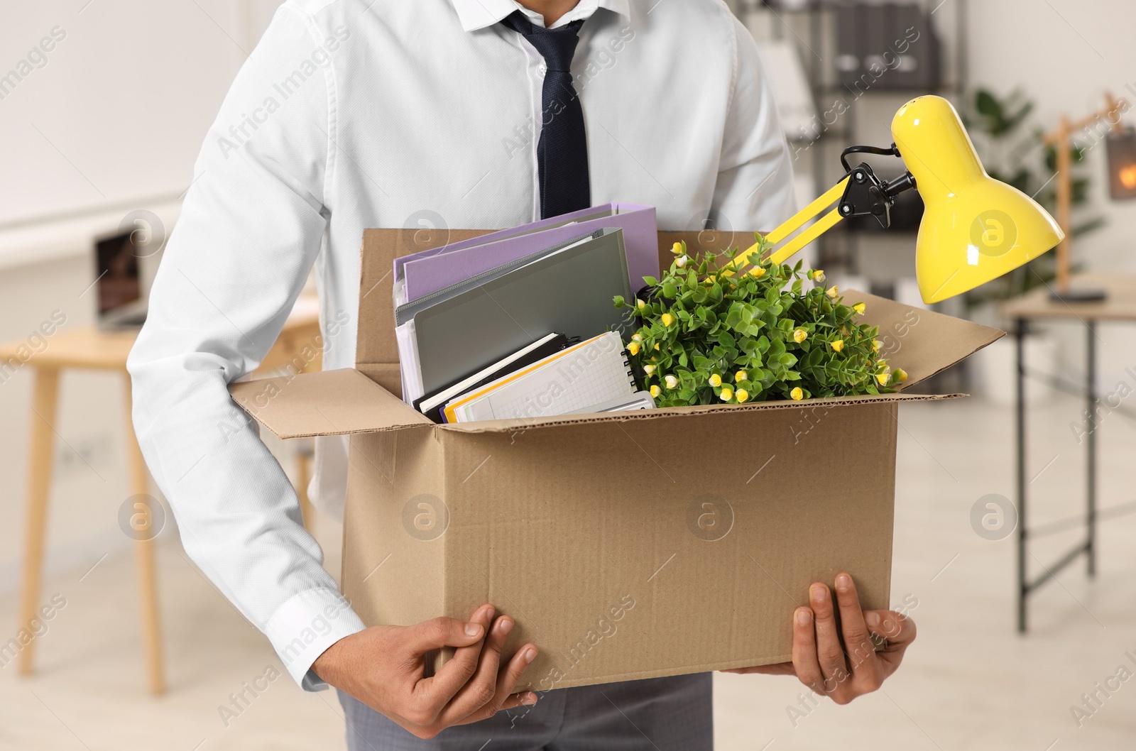 Photo of Unemployment problem. Man with box of personal belongings in office, closeup