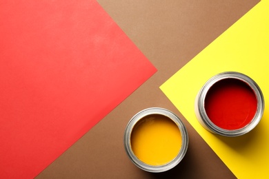 Flat lay composition with paint cans and space for text on color background