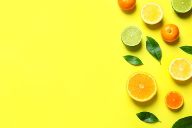 Photo of Different citrus fruits and leaves on color background, flat lay. Space for text