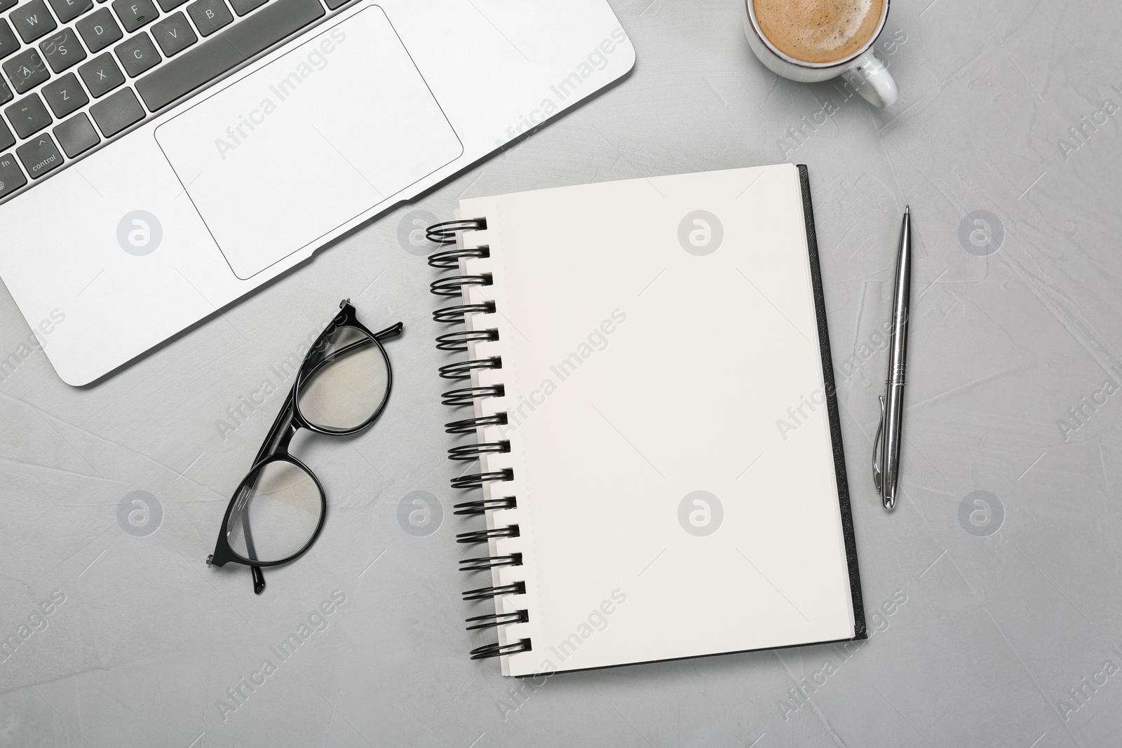 Photo of Flat lay composition with open notebook and laptop on light grey table