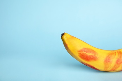 Photo of Fresh banana with red lipstick marks on blue background, space for text. Oral sex concept