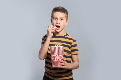 Photo of Boy with popcorn during cinema show on grey background