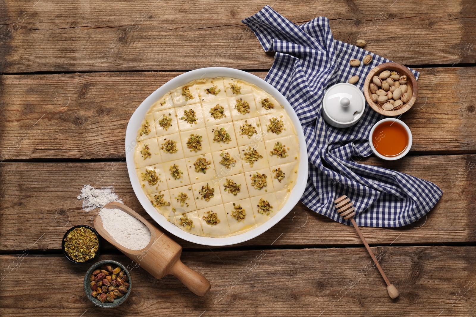 Photo of Making delicious baklava. Raw dough with ingredients on wooden table, flat lay